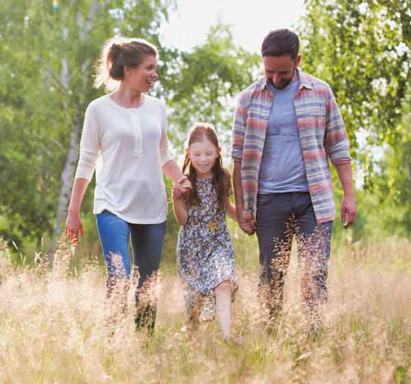 family walking through grass outdoors